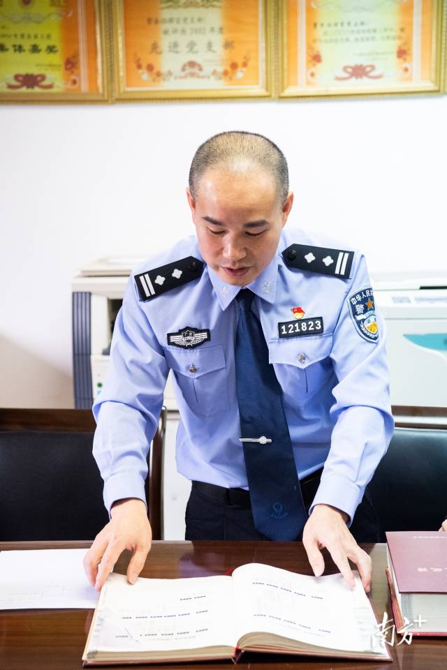 民警查阅族谱寻找烈士后人线索。张劲夫 摄