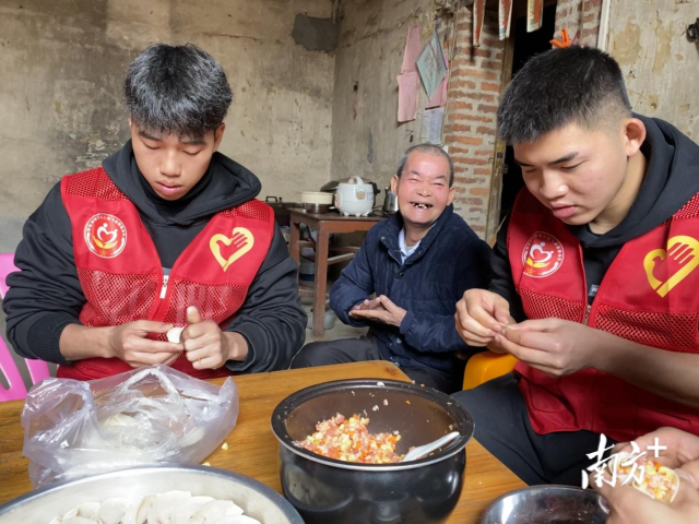 志愿者与老兵一同包饺子。通讯员供图